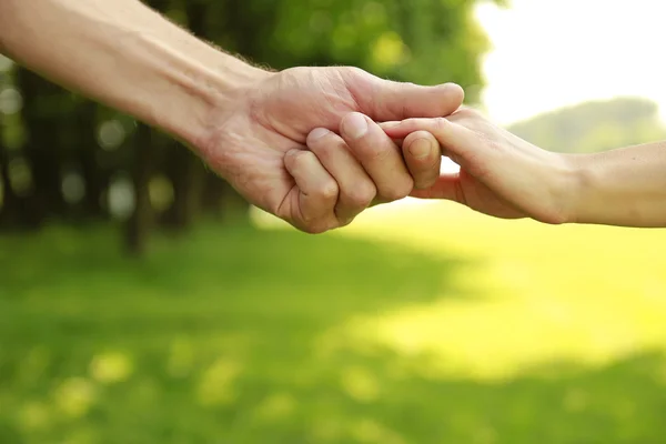 Two hands of a loving couple on nature — Stock Photo, Image