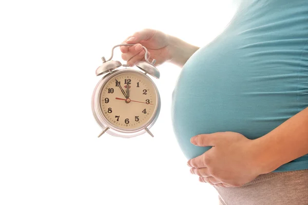 Kobieta w ciąży z zegarem na białym tle — Zdjęcie stockowe