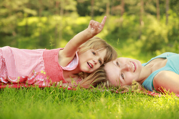 Mother playing with her little daughter on the grass