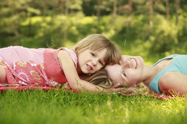Moeder spelen met haar dochtertje op het gras — Stockfoto