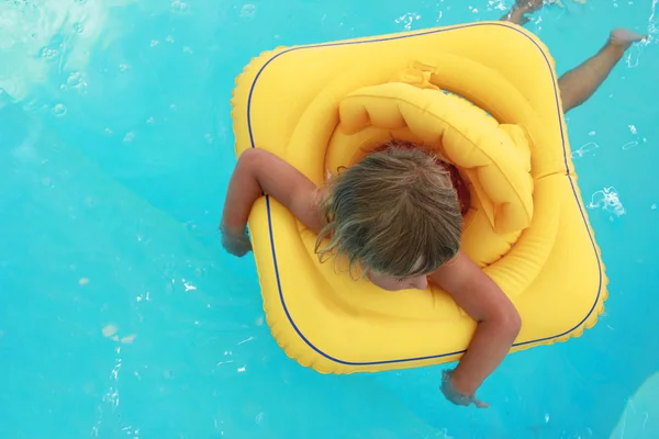 Flicka simmar i en pool med en cirkel — Stockfoto