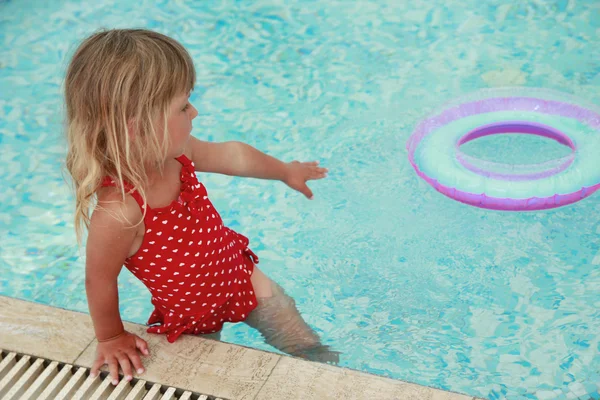 Meisje zwemt in een zwembad met een cirkel — Stockfoto