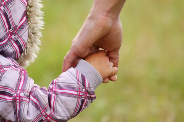 Bovenliggende houdt de hand van een kind — Stockfoto