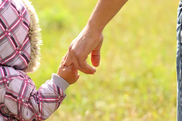 Bovenliggende houdt de hand van een kind — Stockfoto