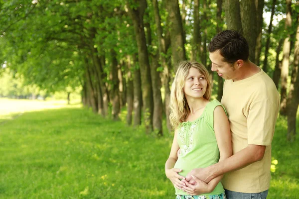 Pregnant couple on nature — Stock Photo, Image