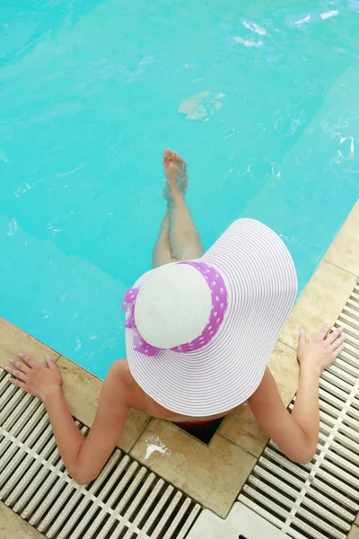 Jong meisje met hoed in water zwembad — Stockfoto