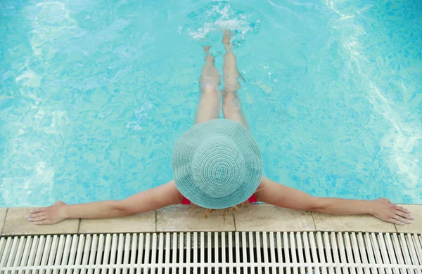 Jovem com chapéu na piscina de água — Fotografia de Stock