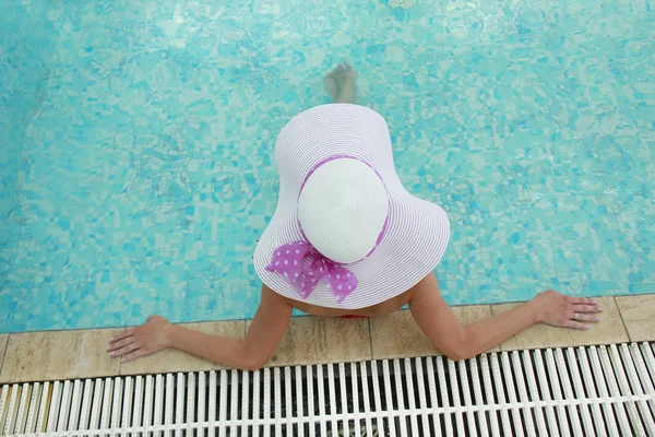 Jovem com chapéu na piscina de água — Fotografia de Stock