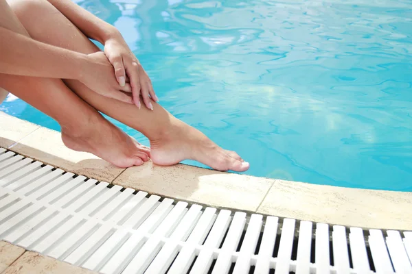 Gambe femminili nella piscina d'acqua — Foto Stock