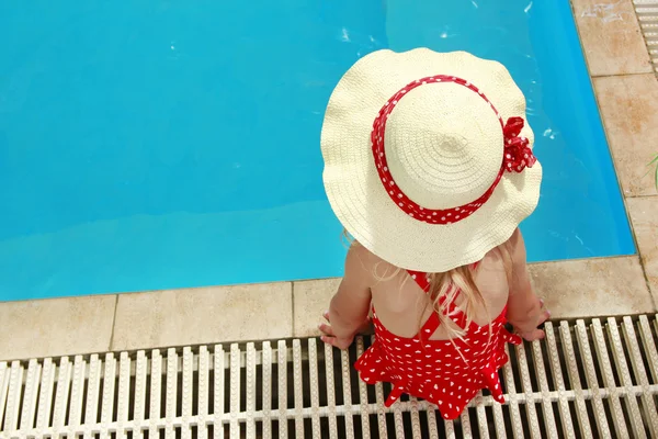 Kleines Mädchen mit Hut schwimmt im Pool — Stockfoto