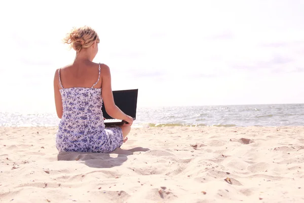 Meisje met laptop op het strand — Stockfoto