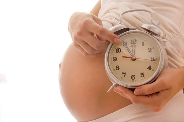 La mujer embarazada con un reloj — Foto de Stock