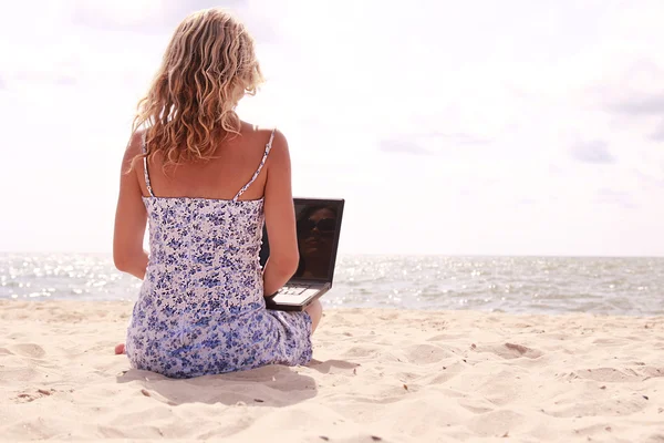 Fille avec ordinateur portable sur la plage — Photo