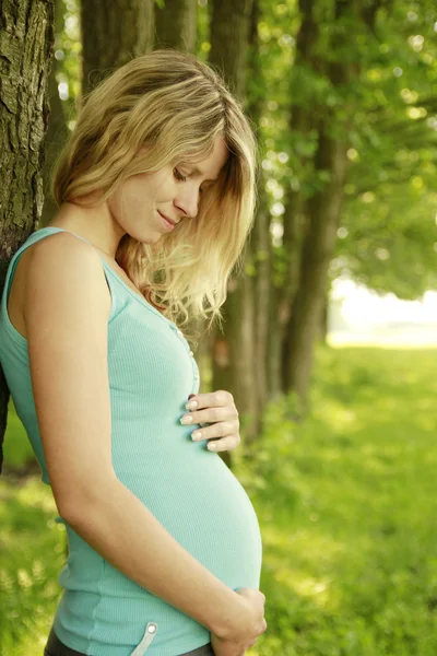 Молодая беременная девушка на природе — стоковое фото