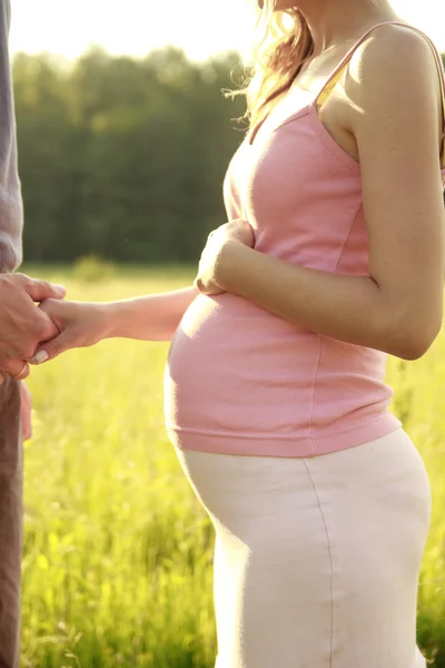 Joven pareja embarazada en la naturaleza — Foto de Stock