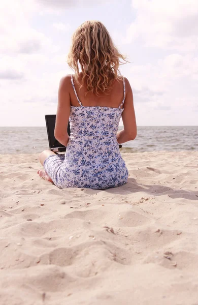 Fille avec ordinateur portable sur la plage — Photo