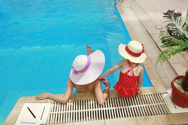 Kleines Mädchen mit Hut und Mutter im Schwimmbad — Stockfoto
