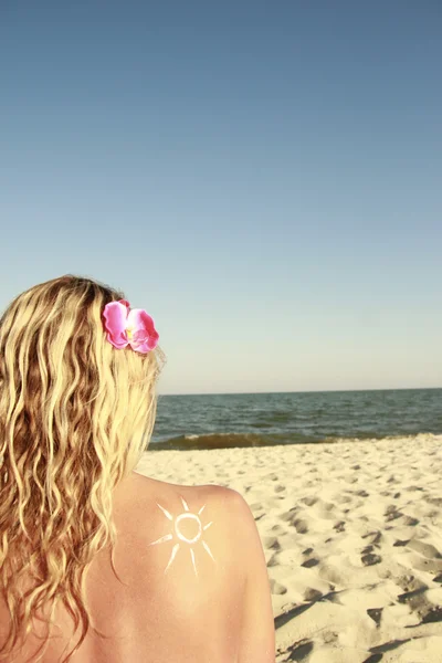Of sun cream on the female back on the beach — Stock Photo, Image