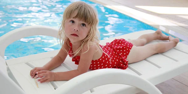 Chica acostada al lado de la piscina — Foto de Stock