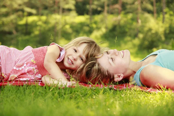 Mama en haar dochtertje spelen op gras — Stockfoto