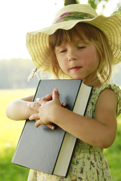 Beautiful little girl with the Bible in nature — Stock Photo, Image