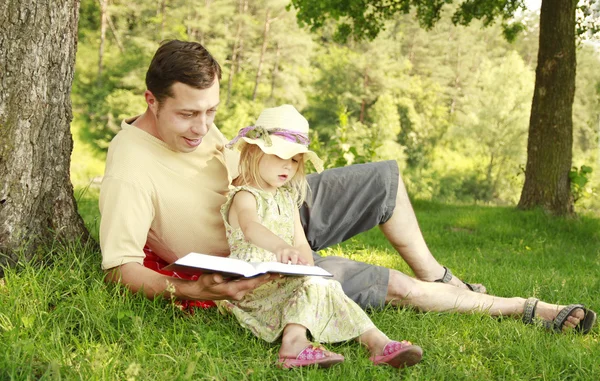 Young father with his little daughter reads the Bible — Stock Photo, Image