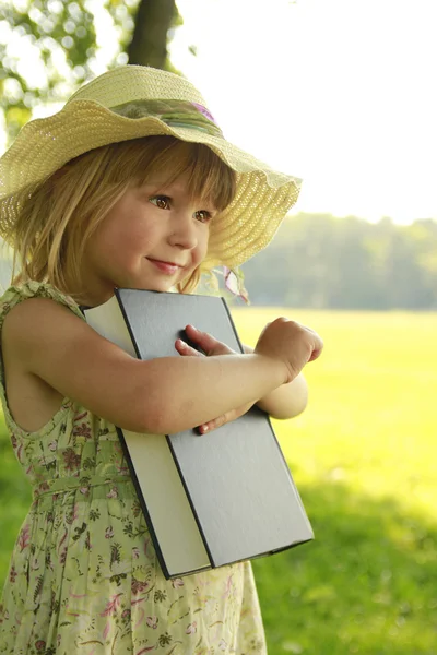 Beautiful little girl with the Bible in nature — Stock Photo, Image