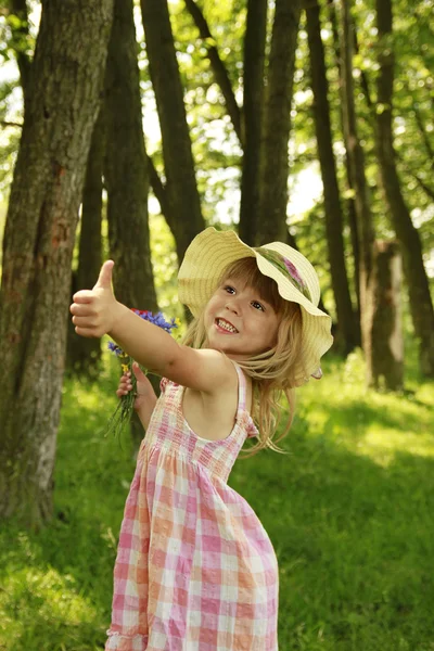 Mooi meisje op natuur met een boeket van bloemen — Stockfoto