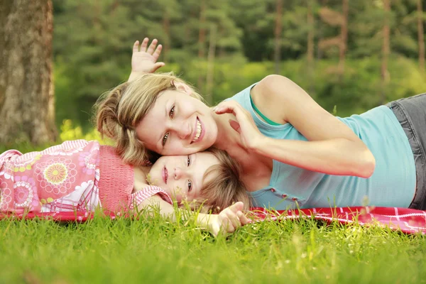 妈妈和她的小女儿躺在草地上 — 图库照片