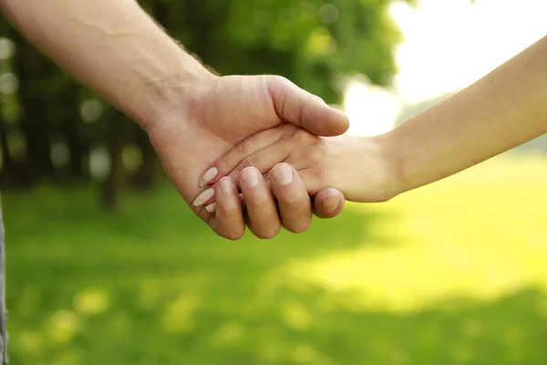 Two young lovers hands on nature — Stock Photo, Image