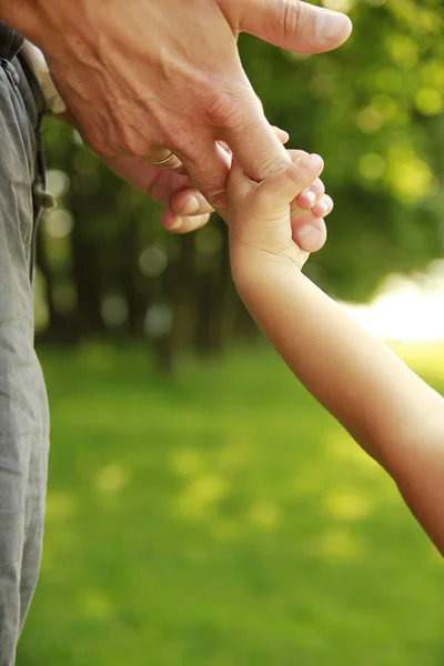 Eltern halten die Hand eines kleinen Kindes — Stockfoto