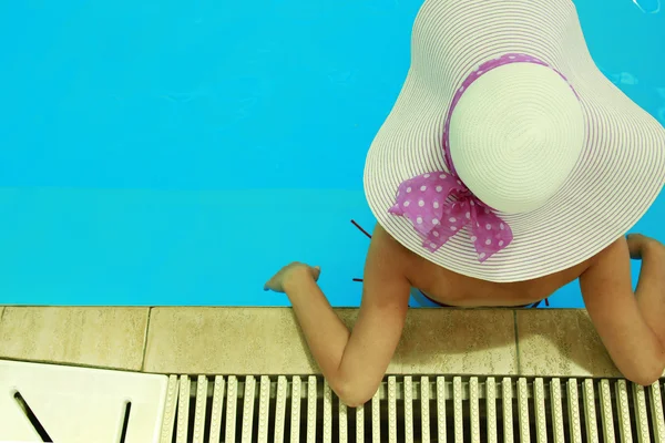 Meisje in een hoed in de pool water — Stockfoto