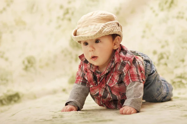 Infant baby in a hat on a green background — Stock Photo, Image