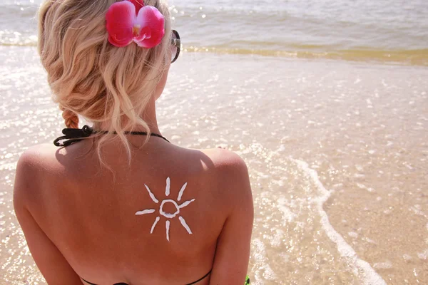 Of sun cream on the female back on the beach — Stock Photo, Image