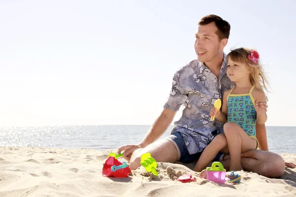 Papá y su pequeña hija jugando en la playa — Foto de Stock