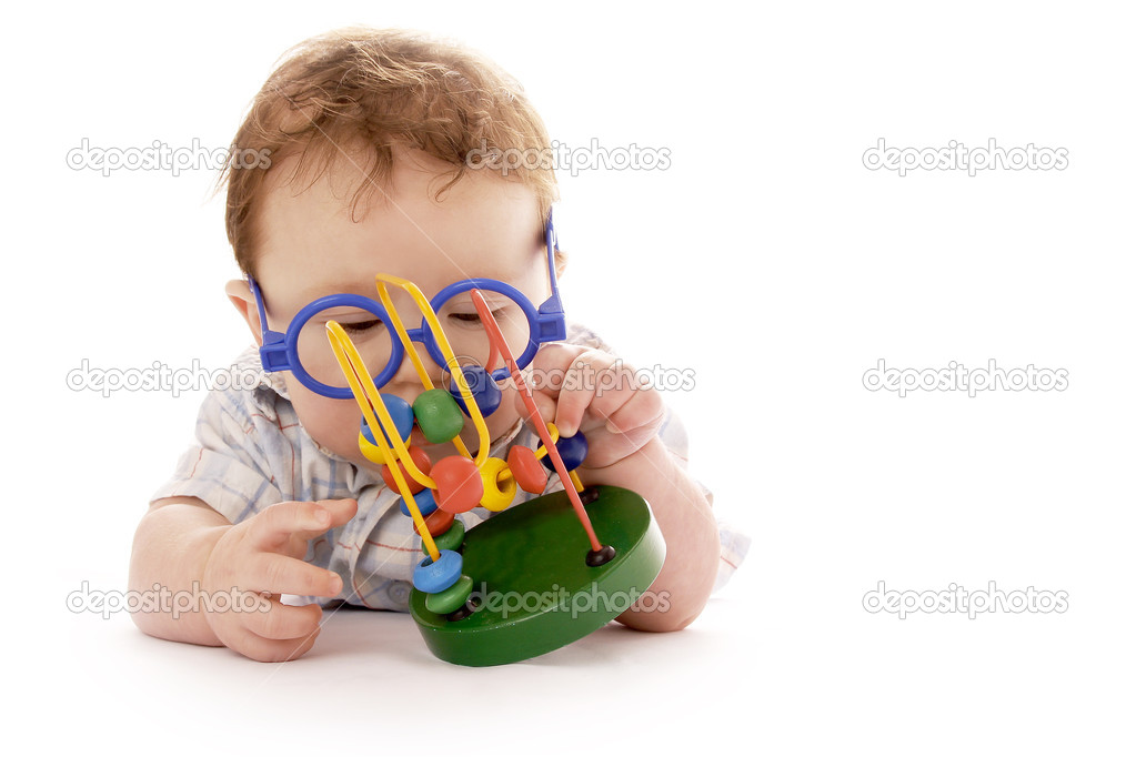 Infant baby on a white background in glasses with a toy