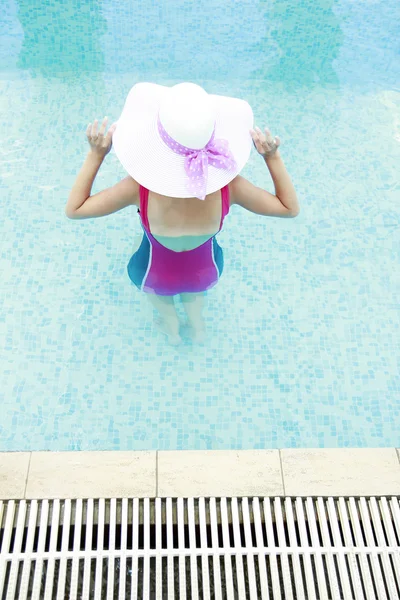 Girl in water pool in hat — Stock Photo, Image