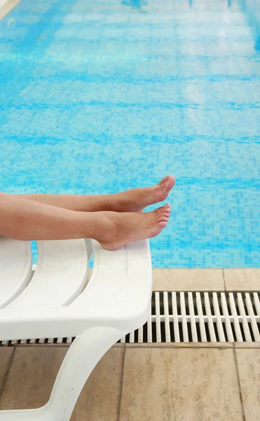 Vrouwelijke benen in het zwembad water — Stockfoto