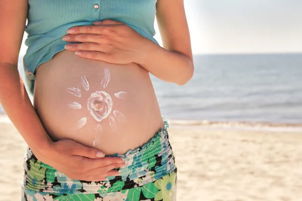 Του αντηλιακή κρέμα επάνω έγκυος κοιλιά της γυναίκας στην παραλία — Φωτογραφία Αρχείου