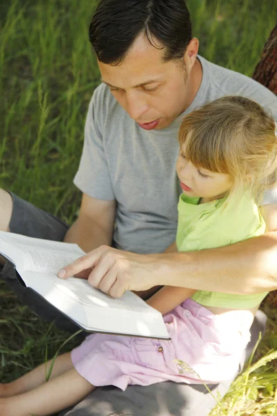 Giovane padre con la figlioletta legge la Bibbia — Foto Stock