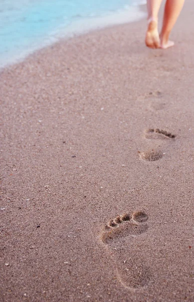 Empreintes de pas des femmes dans le sable — Photo