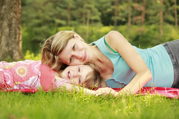 Mama and her little daughter lie on the grass — Stock Photo, Image