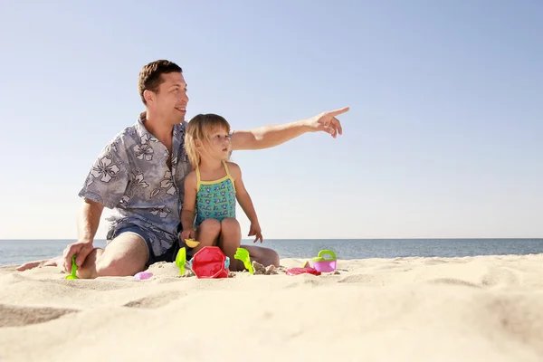 Pappa och lilla dotter spelar på stranden — Stockfoto