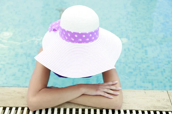 Meisje in water zwembad in hoed — Stockfoto