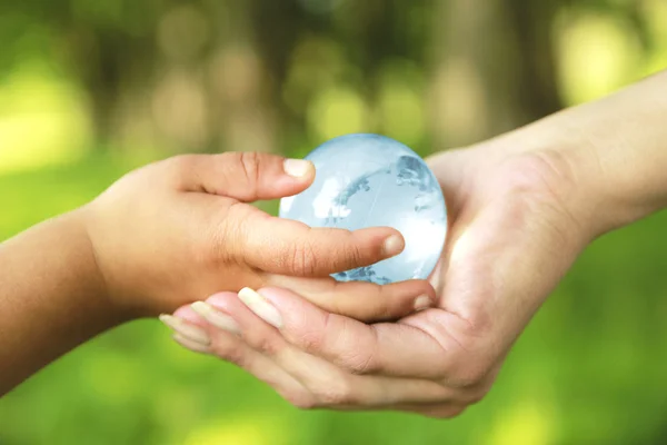 Glass globe in hands — Stock Photo, Image