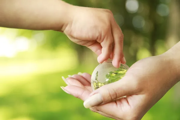 Glass globe in hands — Stock Photo, Image