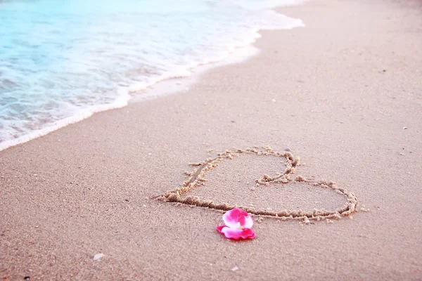 Corazón en la arena en la orilla del mar — Foto de Stock