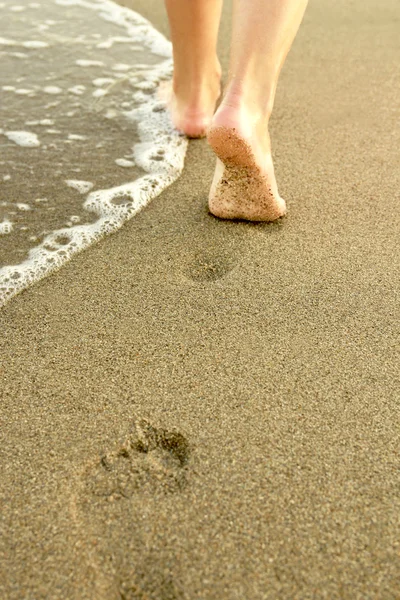 Menina deixa pegadas na areia — Fotografia de Stock