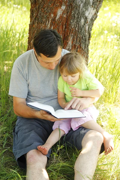 Mladý otec s dcerou čte Bibli — Stock fotografie