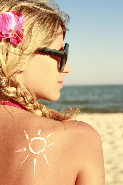 Creme solar nas costas femininas — Fotografia de Stock